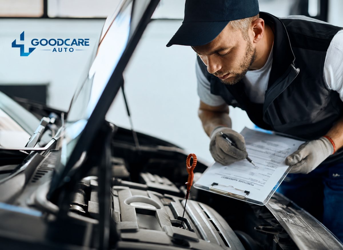 A mechanic is inspecting a car engine while holding a clipboard and the engine dipstick is visible.
